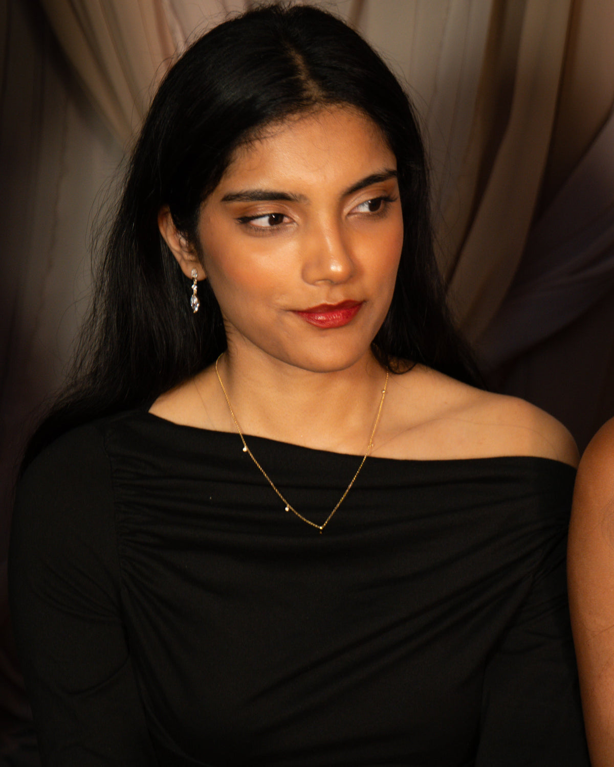 The Gaze gold marquise drop earring worn on the ear, three clear stones on fine gold links