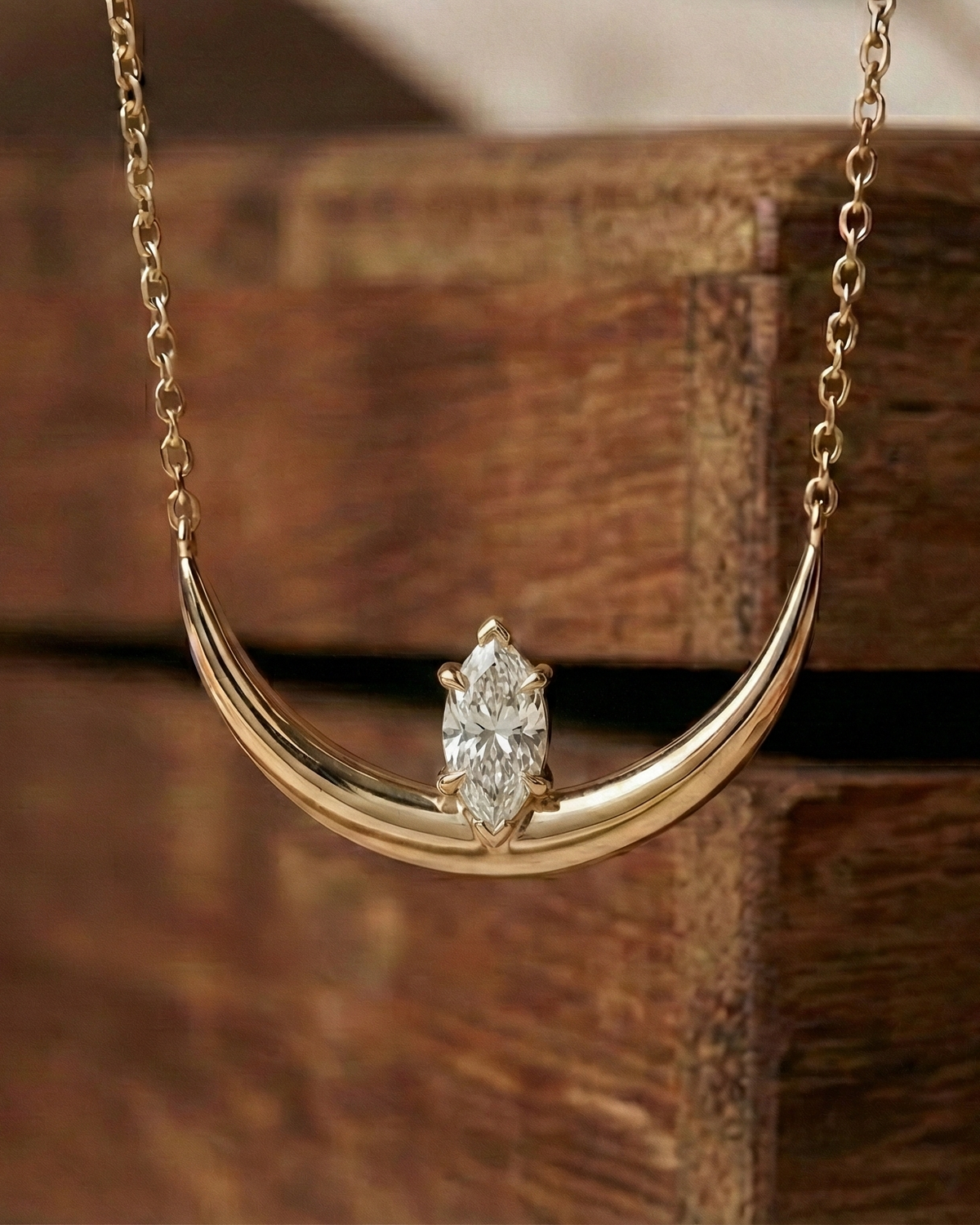 Gold vermeil  necklace with a Marquise zircon pendant on a wooden surface