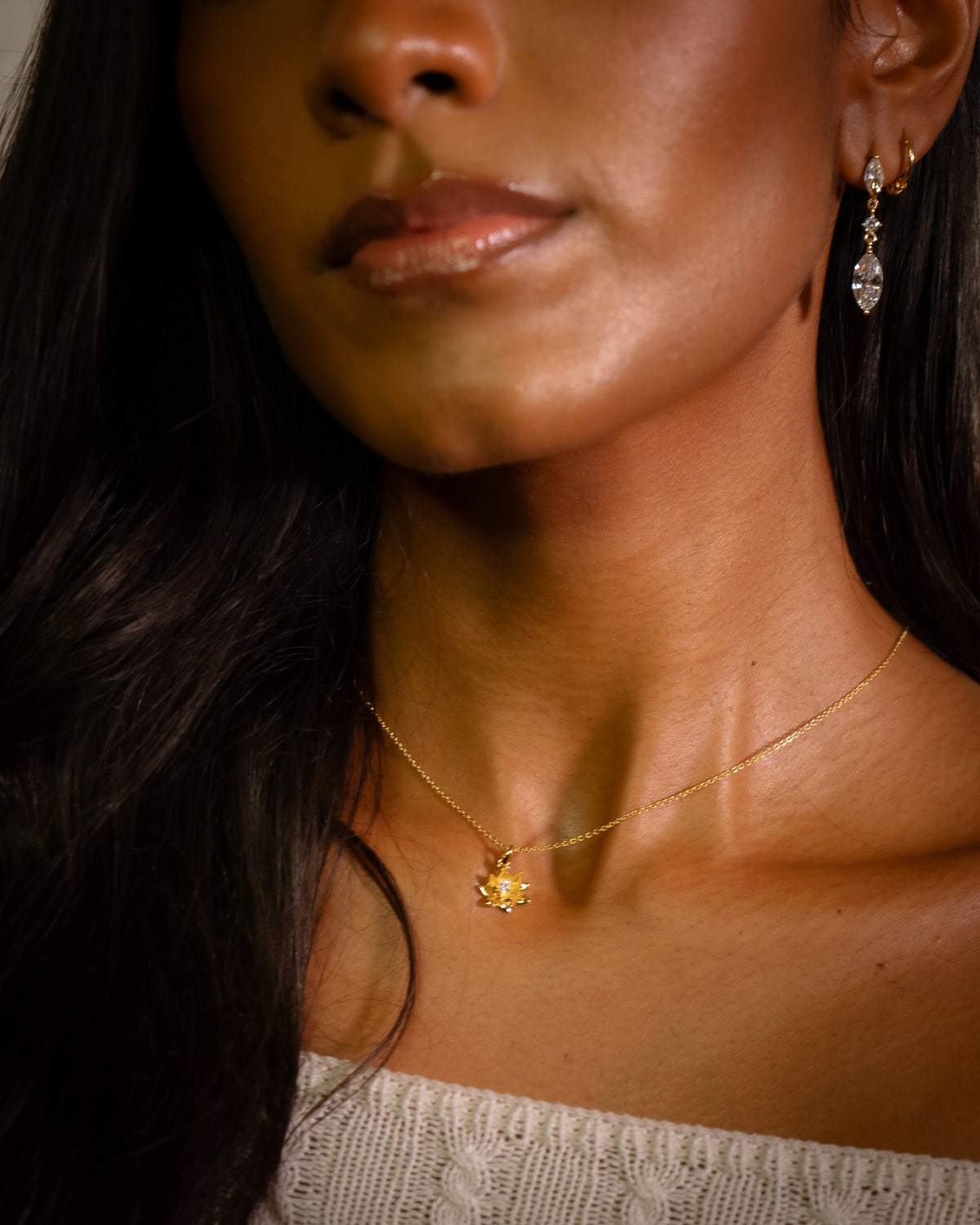 The Gaze gold marquise drop earring worn on the ear, three clear stones on fine gold links